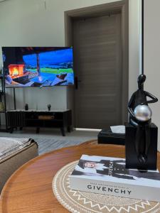 a living room with a tv and a table at شقة أنيقة جديده في قلب أبها in Abha