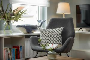 a gray chair with a pillow on a table at Ferienwohnung Villa Central - Lüttje Nüst in Borkum