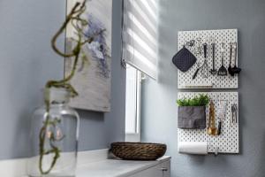 a kitchen with a white rack with utensils on a wall at Ferienwohnung Villa Central - Lüttje Nüst in Borkum +3 photos