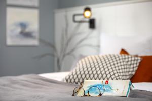 a book and a pair of glasses on a bed at Ferienwohnung Villa Central - Lüttje Nüst in Borkum