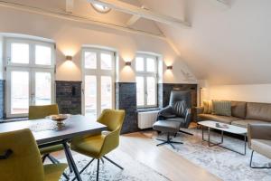 a living room with a couch and a table and chairs at Commandeur-Huus Wohnung 3 in Borkum