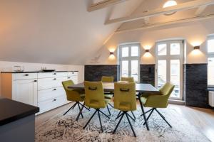 a kitchen with a dining room table and yellow chairs at Commandeur-Huus Wohnung 3 in Borkum
