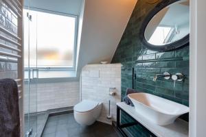 a bathroom with a sink and a toilet and a mirror at Commandeur-Huus Wohnung 3 in Borkum