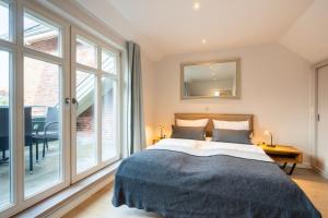 a bedroom with a large bed and a large window at Commandeur-Huus Wohnung 3 in Borkum