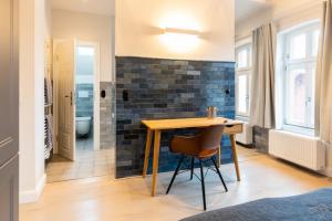 a dining room with a table and a brick wall at Commandeur-Huus Wohnung 3 in Borkum +14 photos