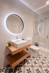 a bathroom with a sink and a mirror and a toilet at Darm in Lamego