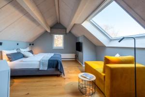 a bedroom with a bed and a couch in a attic at Ferienwohnung 2 K20 in Borkum +16 photos