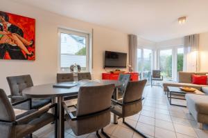 a dining room and living room with a table and chairs at Haus Stranddüne in Borkum
