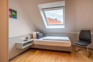 a small bedroom with a bed and a window at Haus Stranddüne in Borkum