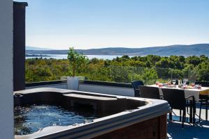 a hot tub on top of a balcony with a table at My Dalmatia - Sea View Villa Senti with private pool in Starigrad