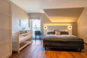 a bedroom with a large bed and a baby crib at Haus Tidehuus in Borkum