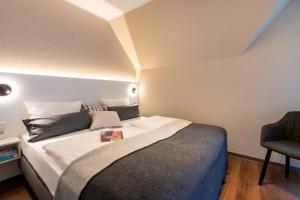 a bedroom with a large bed and a chair at Haus Tidehuus in Borkum