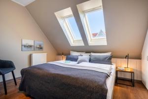 a bedroom with a large bed with two windows at Haus Tidehuus in Borkum +5 photos