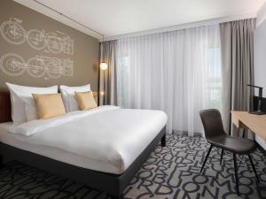 a hotel room with a large bed and a desk at Mercure Warszawa Ursus Station in Warsaw +113 photos
