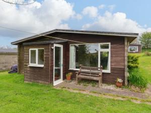 a small house with a bench in a yard at Sea Breeze in Bideford