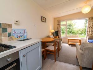 a kitchen and living room with a table and a couch at Sea Breeze in Bideford +10 photos