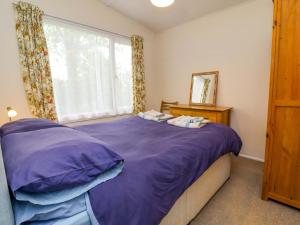 a bedroom with a purple bed with a window at Sea Breeze in Bideford