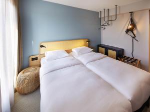 a bedroom with a large white bed in a room at ibis Styles Bayreuth in Bayreuth