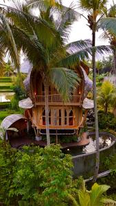a house in the middle of a palm tree at Green Lander Ubud in Ubud