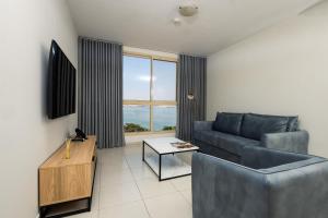 a living room with a couch and a table at Almar Aparthotel in Lobito