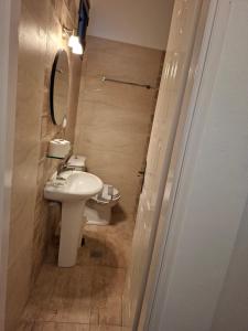 a bathroom with a white sink and a toilet at Valeta Studios in Armenistis