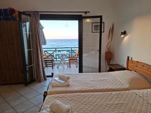 a bedroom with a bed and a view of the ocean at Valeta Studios in Armenistis