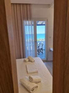 a bedroom with a bed with a view of the ocean at Villa Maniati Chrissi Ammos in Agios Petros