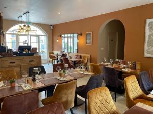 a dining room with tables and chairs and a restaurant at Clos De La Gourmandière, Maison d'hôtes & Restaurant in Saint-Lothain