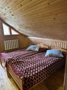 a bedroom with two beds in a wooden cabin at River Side Retreat in Slavske