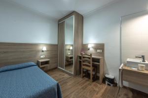 a bedroom with a bed and a sink and a mirror at Pensión San Andrés I in Jerez de la Frontera +17 photos