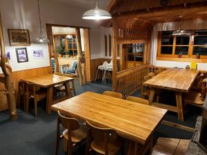 a dining room with wooden tables and chairs at Horský hotel Portáš in Nový Hrozenkov