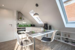 a white kitchen with a table and two chairs at Haus Nordstern Wohnung 5 in Borkum