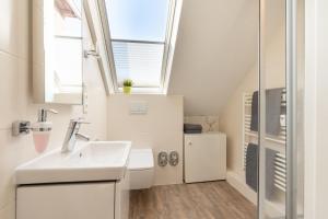a bathroom with a sink and a window at Haus Nordstern Wohnung 5 in Borkum