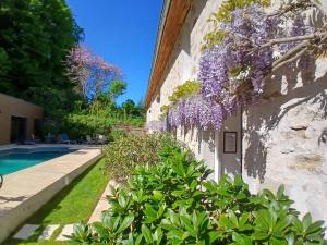 a building with purple flowers on the side of it at Clos De La Gourmandière, Maison d'hôtes & Restaurant in Saint-Lothain