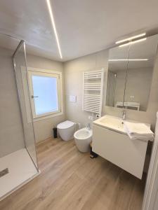 a bathroom with a sink and a toilet and a mirror at Casa Historia in Caorle +6 photos