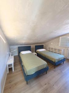 a room with two beds and a table with a lamp at Casa Historia in Caorle