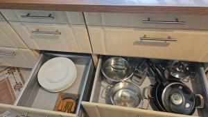an open drawer with pots and pans in a kitchen at Zacisze Stasia Ustroń in Nierodzim +39 photos