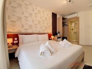 a bedroom with a large white bed with towels on it at Lepanto Guesthouse in Misraħ Il-Barrieri