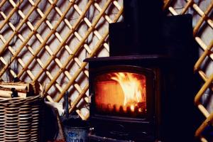 a fireplace in front of a wooden wall at Wester Auchraw Croft B&B in Lochearnhead +21 photos
