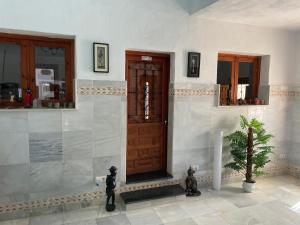 a room with a wooden door and a potted plant at Guest Wing at Casa Africa in Lorca