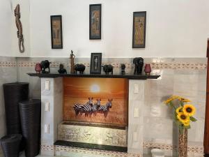 a fireplace with a painting of zebras on it at Guest Wing at Casa Africa in Lorca