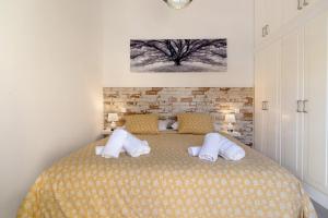 a bedroom with a bed with white pillows at Bungalow Sonemar Paradise in Maspalomas +19 photos