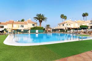 a large swimming pool in a resort with palm trees at Bungalow Sonemar Paradise in Maspalomas