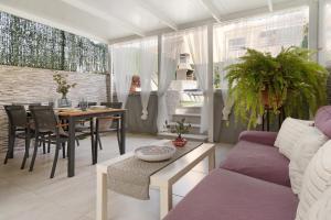a living room with a purple couch and a table at Bungalow Sonemar Paradise in Maspalomas