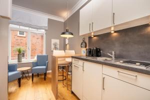 a kitchen with white cabinets and a counter top at Logierhaus K15 Appartement 4 Plus in Borkum