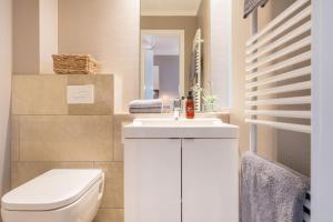 a bathroom with a white toilet and a sink at Logierhaus K15 Appartement 4 Plus in Borkum