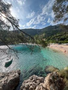 a boat in the water next to a beach at Guest House Estela in Vela Luka