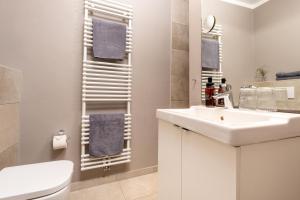 a bathroom with a sink and a toilet and a mirror at Logierhaus K15 Appartement 8 in Borkum