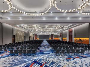 a large room with chairs and a stage with chandeliers at Pullman Bandung Grand Central in Bandung +138 photos