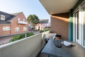 a table on a balcony with a view of a building at Ferienwohnung Deck7 in Borkum +2 photos